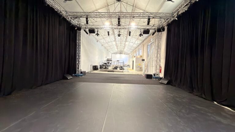 Show Reel warehouse with trussing and black drapes for set builds, in Lisbon